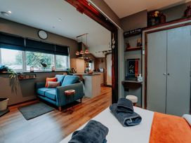 A living room with a sofa and a kitchenette at TyCosy in St Davids