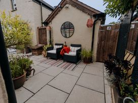 An outdoor seating area with a round mirror and planters at TyCosy in St Davids