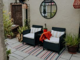 An outdoor seating area with two armchairs and a mirror at TyCosy St Davids
