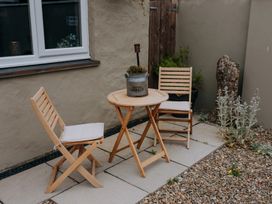 A garden with a table and two chairs at TyCosy in St Davids