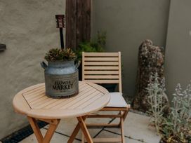 A table and chair with a planter in a garden at TyCosy St Davids