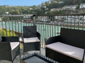 A balcony with chairs and a table overlooking a body of water at Rivercrest in Looe