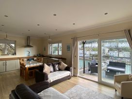 A living room with a dining area and kitchen at Rivercrest in Looe