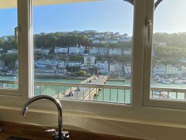 A kitchen with a view of a bridge and houses at Rivercrest in Looe