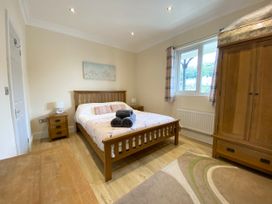 A bedroom with a bed and wardrobe at Rivercrest in Looe