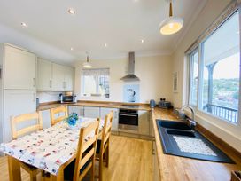 A kitchen with a table and chairs at Rivercrest in Looe