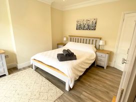 A bedroom with a bed and nightstands at Nesden House