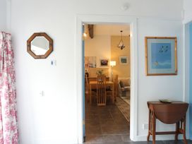 An entryway with a mirror and dining area visible at Riverside Cottage in Caernarfon