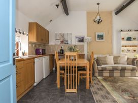 A kitchen with table and chairs and a sofa at Riverside Cottage in Caernarfon