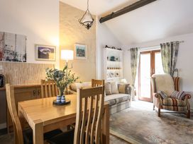 A living room with a dining table and chairs at Riverside Cottage in Caernarfon