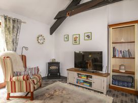 A living room with a television and an armchair at Riverside Cottage in Caernarfon