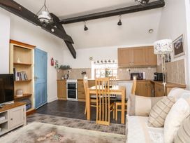 A kitchen with dining table and sofa at Riverside Cottage in Caernarfon