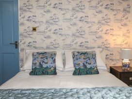 A bedroom with a bed and decorative pillows at Riverside Cottage in Caernarfon