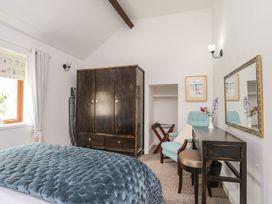 A bedroom with a bed, wardrobe, desk, and chair at Riverside Cottage in Caernarfon