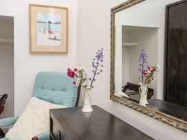 A living room with a chair and a flower vase at Riverside Cottage in Caernarfon