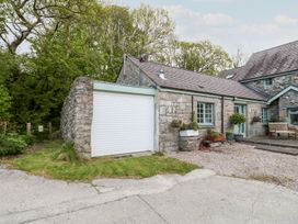 A garage and stone wall with planters at Riverside Cottage in Caernarfon