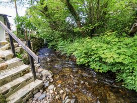 A stream with stairs and vegetation at Riverside Cottage in Caernarfon