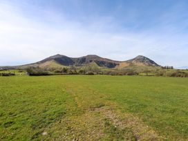 A landscape view of mountains and grass fields at Riverside Cottage in Caernarfon