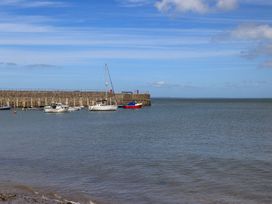 Boats in the water near a pier at Riverside Cottage in Caernarfon