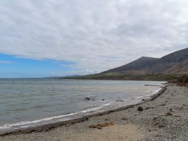 A beach with a shoreline and mountains in the background at Riverside Cottage in Caernarfon