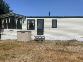 A mobile home with a green door and windows at Windy Ridge in Penzance