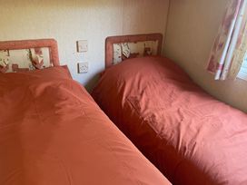 A bedroom with two beds and a window at Windy Ridge in Penzance
