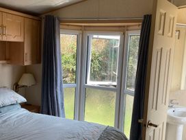 A bedroom with a bed and a window at Windy Ridge in Penzance