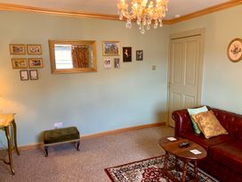 A living room with a sofa and chandelier at Downton II in Alnwick