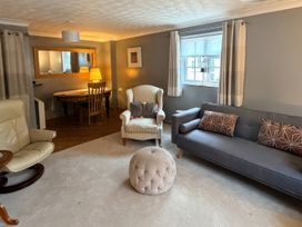 A living room with a sofa a chair and a dining table at No 1 The Martins Walberswick
