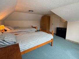 A bedroom with two beds and a wardrobe at No 1 The Martins in Walberswick