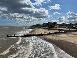 A beach with waves and people at No 1 The Martins Walberswick