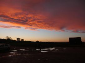 A silhouette of clouds and people with a barn at No 1 The Martins Walberswick