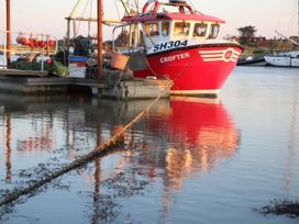 A red fishing boat named CROFTER docked at a marina in Walberswick