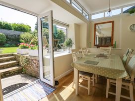 A dining room with a table and chairs leading to an outdoor patio at Mary’s House 