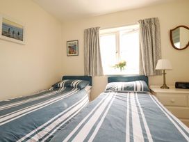A bedroom with two single beds and a window at Mary’s House
