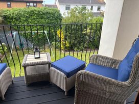 A balcony with wicker furniture and view of garden at 7 Adrian Close Porthcawl