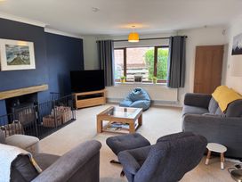 A living room with a sofa, television, and coffee table at 7 Adrian Close in Porthcawl