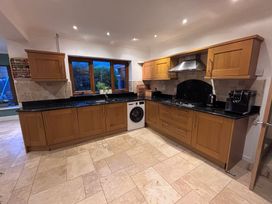 A kitchen with cabinets, a sink, and appliances at 7 Adrian Close Porthcawl