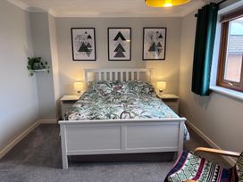 A bedroom with a bed and wall art at 7 Adrian Close in Porthcawl