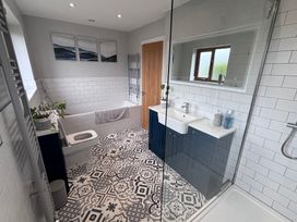 A bathroom with a bathtub, toilet, and sink at 7 Adrian Close in Porthcawl