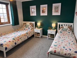 A bedroom with two beds and nightstands at 7 Adrian Close in Porthcawl