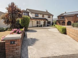A house with a garage and driveway at Ty Traeth in Porthcawl