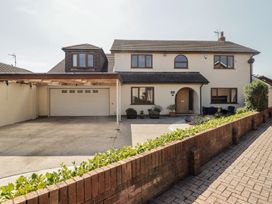 A house with a garage and driveway at Ty Traeth in Porthcawl