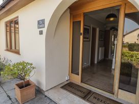 An entrance area with a welcome mat and a plant at Ty Traeth in Porthcawl
