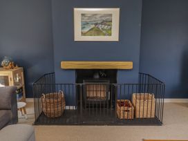 A living room with a fireplace and baskets at Ty Traeth in Porthcawl