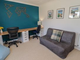 An office with a desk, chairs and wall art at Ty Traeth in Porthcawl