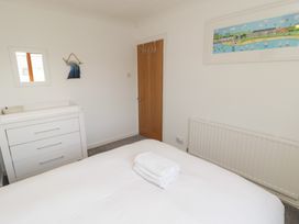 A bedroom with a bed and towel at Ty Traeth in Porthcawl