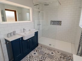 A bathroom with a sink and shower area at Ty Traeth in Porthcawl