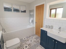 A bathroom with bathtub and washbasin at Ty Traeth in Porthcawl