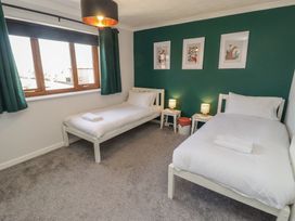 A bedroom with two single beds and wall art at Ty Traeth in Porthcawl